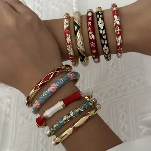 Detailed macro view of stacked ethnic enamel bangles with floral and geometric patterns