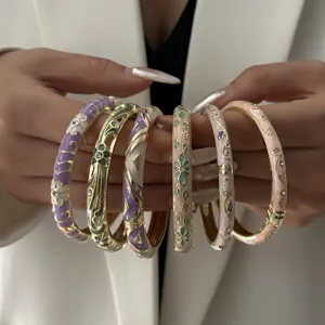 Detailed view of colorful floral cloisonne bangles with intricate drip oil patterns.
