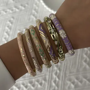 Close-up of stacked ethnic style cloisonne bangles with floral patterns and crystals
