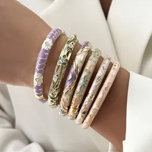 Detailed shot of multi-colored enamel bangles with floral patterns and crystal accents