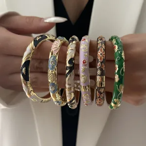 Detail of six ethnic style enamel bangles with intricate floral patterns in various colors