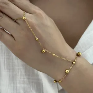 Vue détaillée d'un bracelet de main doré élégant orné de délicats breloques en boules