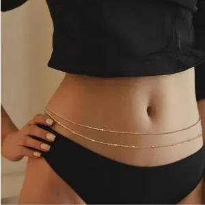 Detailed view of a delicate minimalist double-layer gold waist chain with small beads