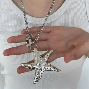 Close-up of a silver starfish pendant necklace with a textured metallic finish on a curb chain