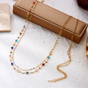 Close-up detail of multi-layer gold waist chain with colorful rhinestones for beach