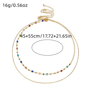Close-up of a layered gold body chain featuring vibrant colorful rhinestones and dimensions