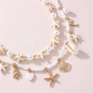 Macro detail of beach-themed beaded necklace with starfish, shell, and heart charms