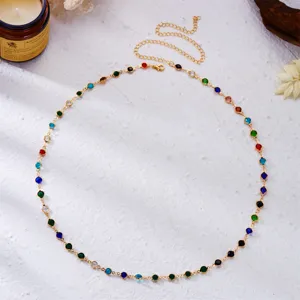 Detailed view of colorful rhinestone body chain on white textured background