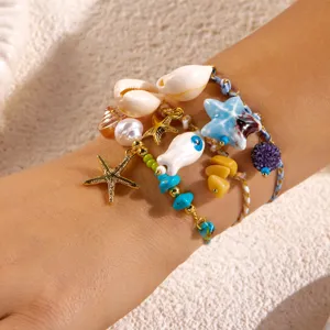 Detailed view of bohemian beach bracelet with ocean shell and starfish charms on wrist