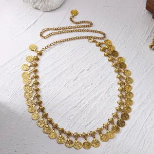Detail shot of golden ethnic coin waist chain with intricate vintage embossed pendants