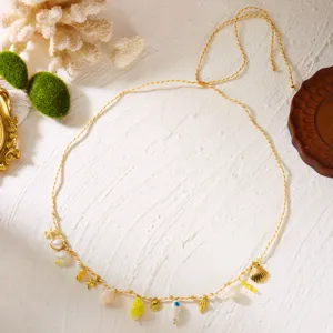 Detailed macro view of a Bohemian beach waist chain with shells and golden starfish charms