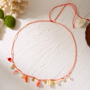 Detail view of a bohemian beach style waist chain featuring natural shells and starfish charms