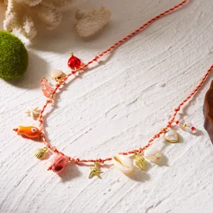 Macro detail of bohemian beach waist chain featuring sea shell and starfish charms