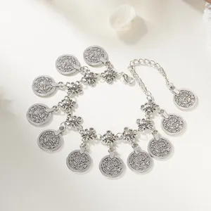 Close-up view of antique silver coin body chain with intricate bohemian tassels