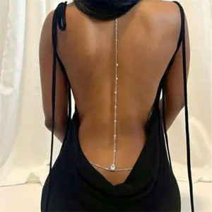 Close-up of elegant silver back chain jewelry on woman in black backless dress