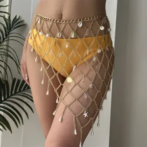 Detail view of gold mesh body chain with shell and pearl charms on yellow bikini.
