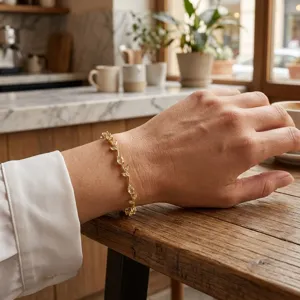 Close-up view of elegant leaf-shaped gold bracelet with clear crystals on a lady's wrist