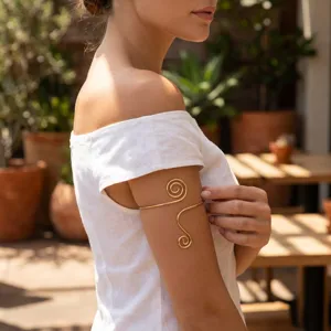 Detailed view of a gold spiral metal arm cuff worn on the upper arm for ethnic styling
