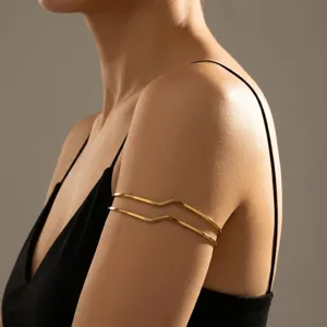 Close-up detail of a minimalist golden wavy geometric double-layer metal armlet for women