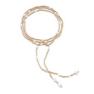 Elegant macro detail showing the intricate gold beads and white pearls on the long tassel necklace