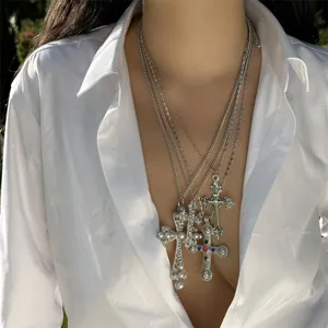 Detailed view of layered hip-hop cross necklaces with pearls and colored gemstones