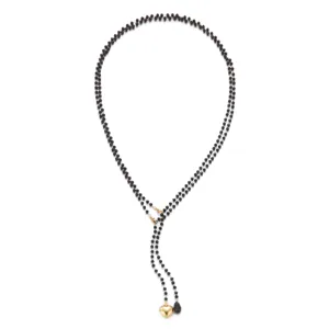 Detailed close-up of a black beaded multi-layer Y-necklace featuring a gold heart pendant.