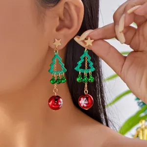 Close-up of festive Christmas tree earrings with green bells and red snowflake balls