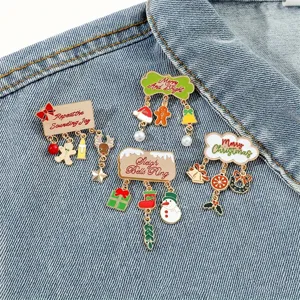 Detailed view of four festive Christmas enamel brooches pinned on blue denim fabric
