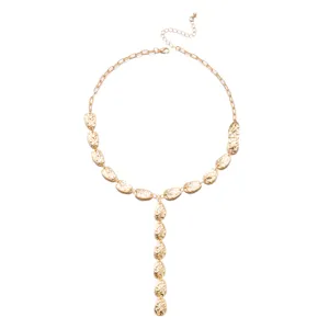 Detailaufnahme einer goldfarbenen Y-Kette mit gehämmerten, tropfenförmigen Anhängern