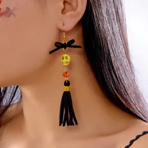 Detail shot of a Halloween skull tassel earring with black bow and yellow skull bead on ear