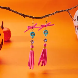 Handmade Halloween tassel earrings featuring blue skull beads and pink ribbon bows
