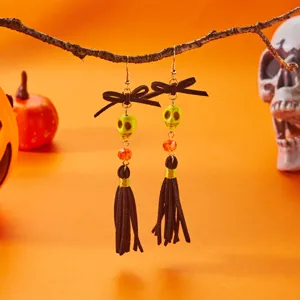Close-up of Halloween skull tassel earrings with black bow hanging on branch