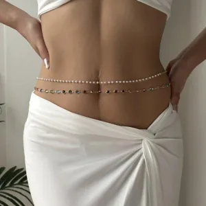 Close-up view of elegant white pearl and colorful gemstone waist chains on a model's waist
