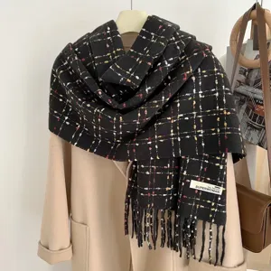 Detailed view of women's black plaid fringe winter scarf, cozy warm knitted wrap accessory.