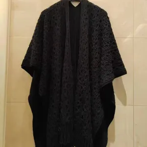 Zwarte gebreide franje sjaal detail, elegante herfst buitenlaag, gezellige comfortabele stijl.