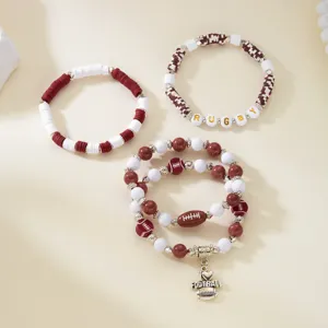 Close-up of sports-themed beaded bracelets featuring football charms and rugby text