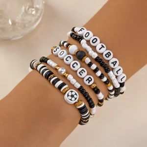 Close-up detail of sports-themed bracelets with soccer and football letter beads