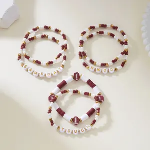 Macro view of football themed beaded bracelets with Gameday and Touch letter beads