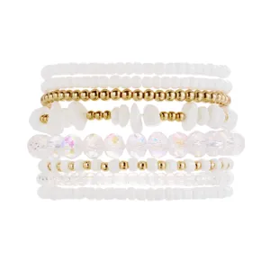 Close-up detail of bohemian white and gold beaded bracelet stack with crystal accents