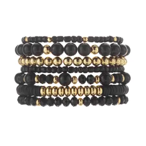 Detailed macro view of bohemian layered beaded bracelet set in black and gold finish