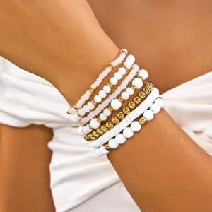 Close-up of bohemian white and gold beaded bracelet set worn on wrist for trendy styling