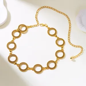 Detail of vintage gold-tone waist chain featuring intricately carved circular links.