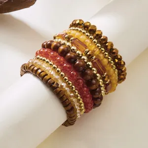 Close-up of Bohemian stacking bracelet set with wood, amber, and gold faceted beads