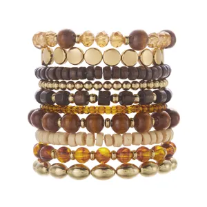 Macro detail view of a bohemian layered bracelet set featuring wood beads and gold accents