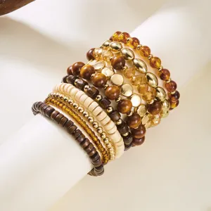Detailed macro view of layered bohemian wood and crystal bead bracelet set