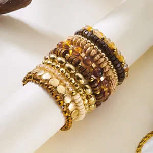 Detailed view of bohemian stacked bracelets featuring wood beads and gold accents.