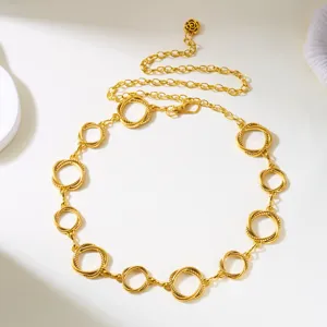 Close-up of vintage golden metal waist chain with textured circular links and rose pendant.