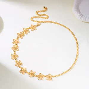 Detailed view of the gold-toned floral chain belt with intricate flower cutouts.