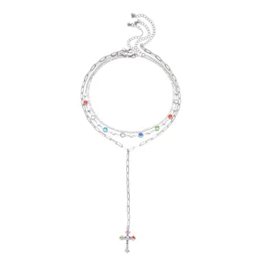 Detailed view of layered silver necklace set with colorful crystals and cross charm