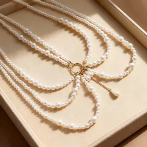 Close-up detail of multi-layer white imitation pearl body chain with a gold ring